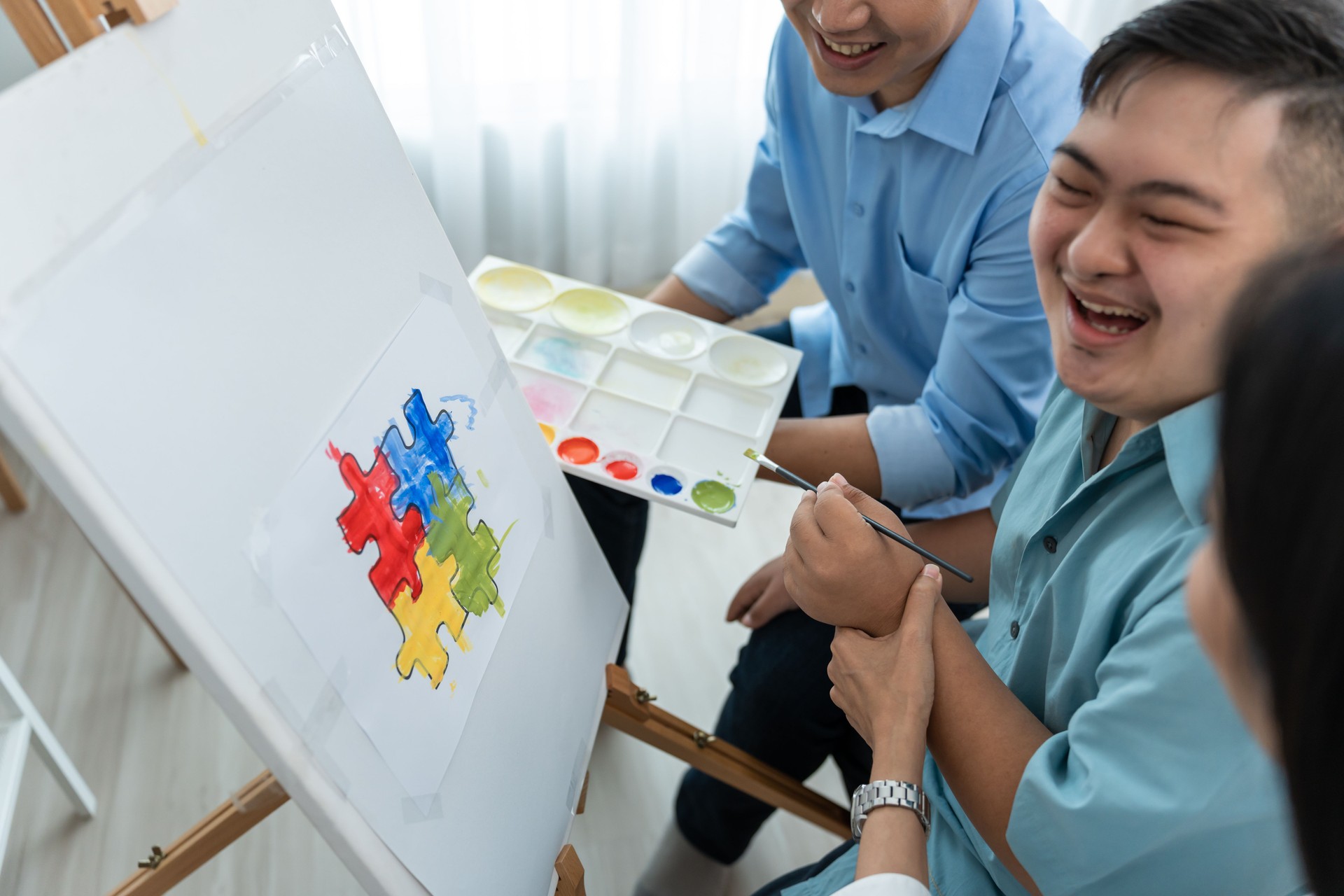 Asian happy family draw picture with young son in living room at home. Beautiful loving mother and father take care and teach young man patient to painting artwork indoors at house. Lifestyle activity